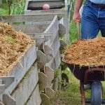 Filling up wooden compost bins.