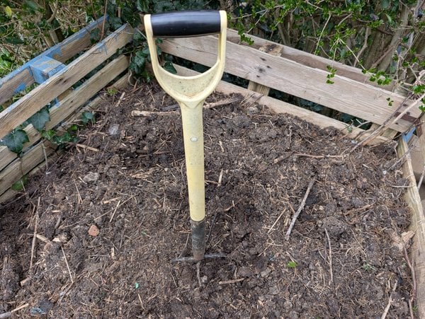 Fork in compost pile.