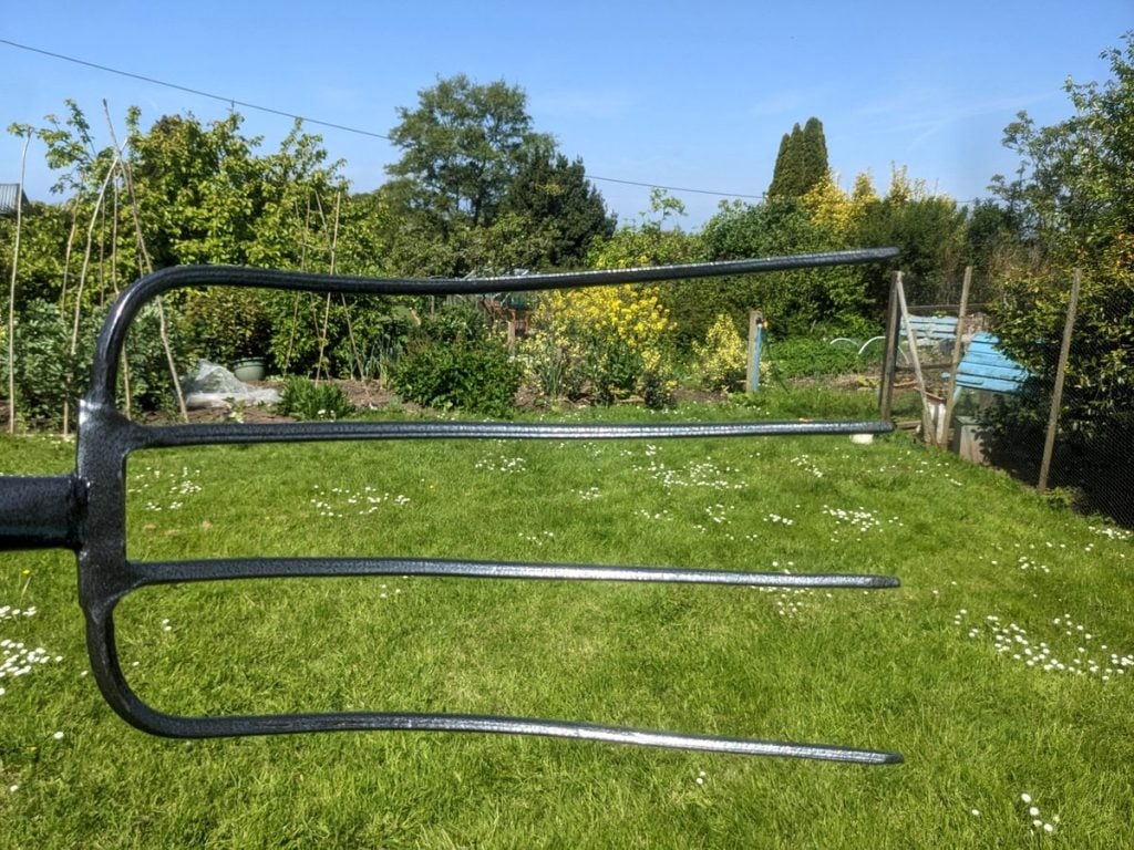 Compost fork pictured against my garden.