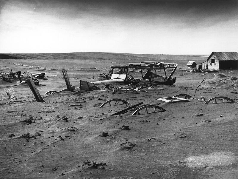 Cars and farm equipment buried in dust from the time of the American dust bowl. 